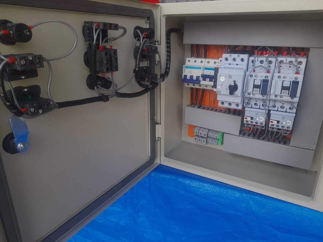 Interior de quadro de comando elétrico, com disjuntores, contatoras e fiação organizada